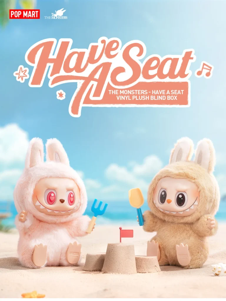 Two Labubu plush toys in fluffy bunny costumes are playing on the beach, with one building a sandcastle and the other holding a tool. The plush toys are part of the 'Have A Seat' series from Pop Mart, with the logo and product name prominently displayed. The toys have playful expressions, and the background features a sunny beach setting